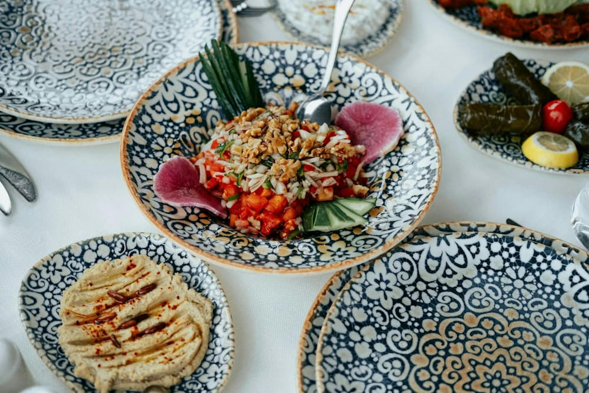 Colorful plate with fresh salad decorated with vegetables and herbs, served on detailed tableware.