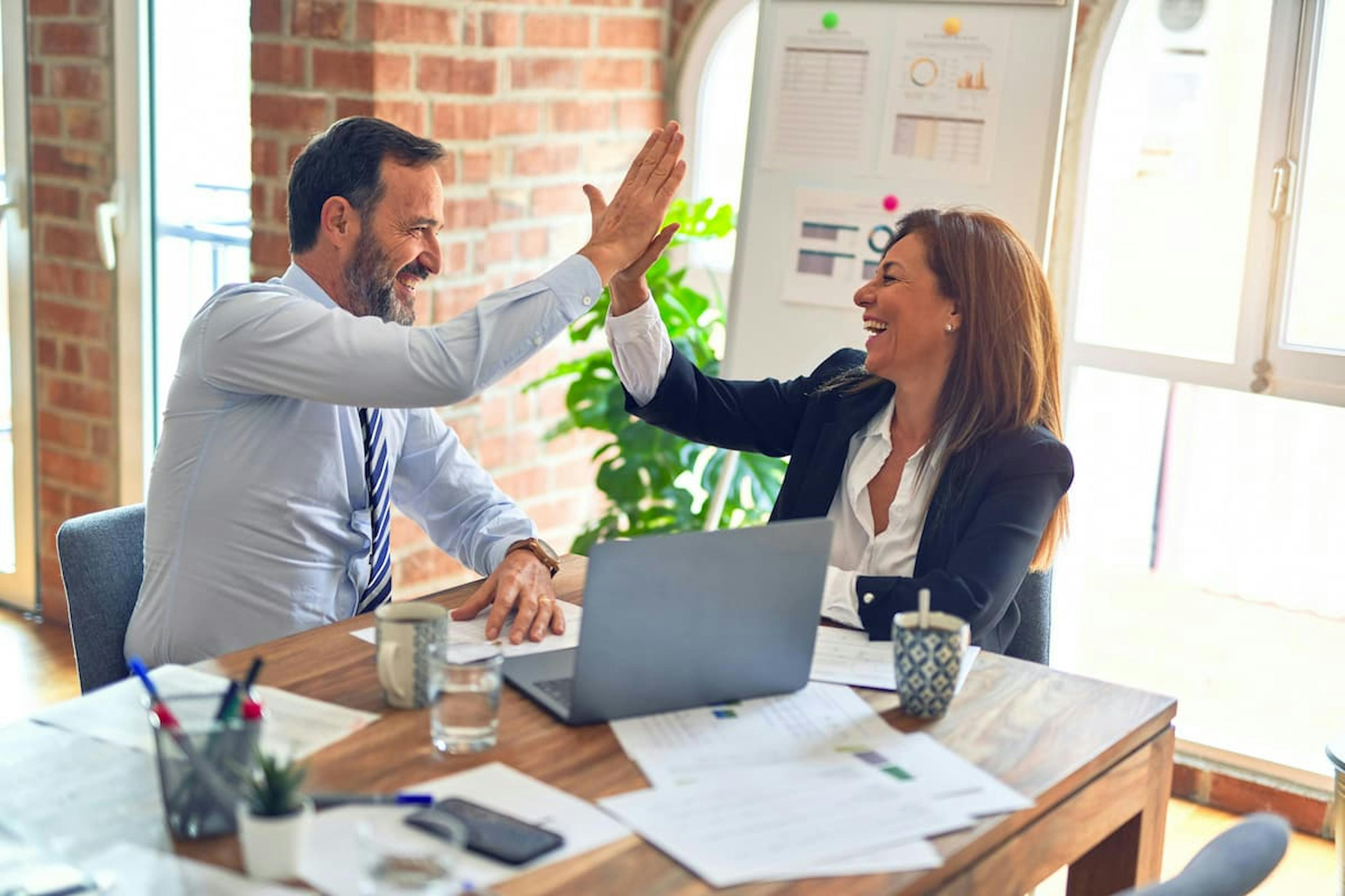 A photograph of two colleagues celebrating an achievement.