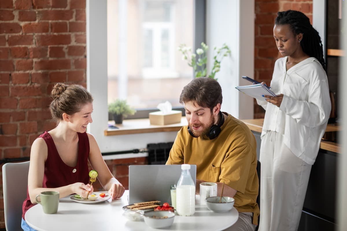 Employees having lunch in a casual office setting, illustrating employee lunch programs vs. traditional food allowances.