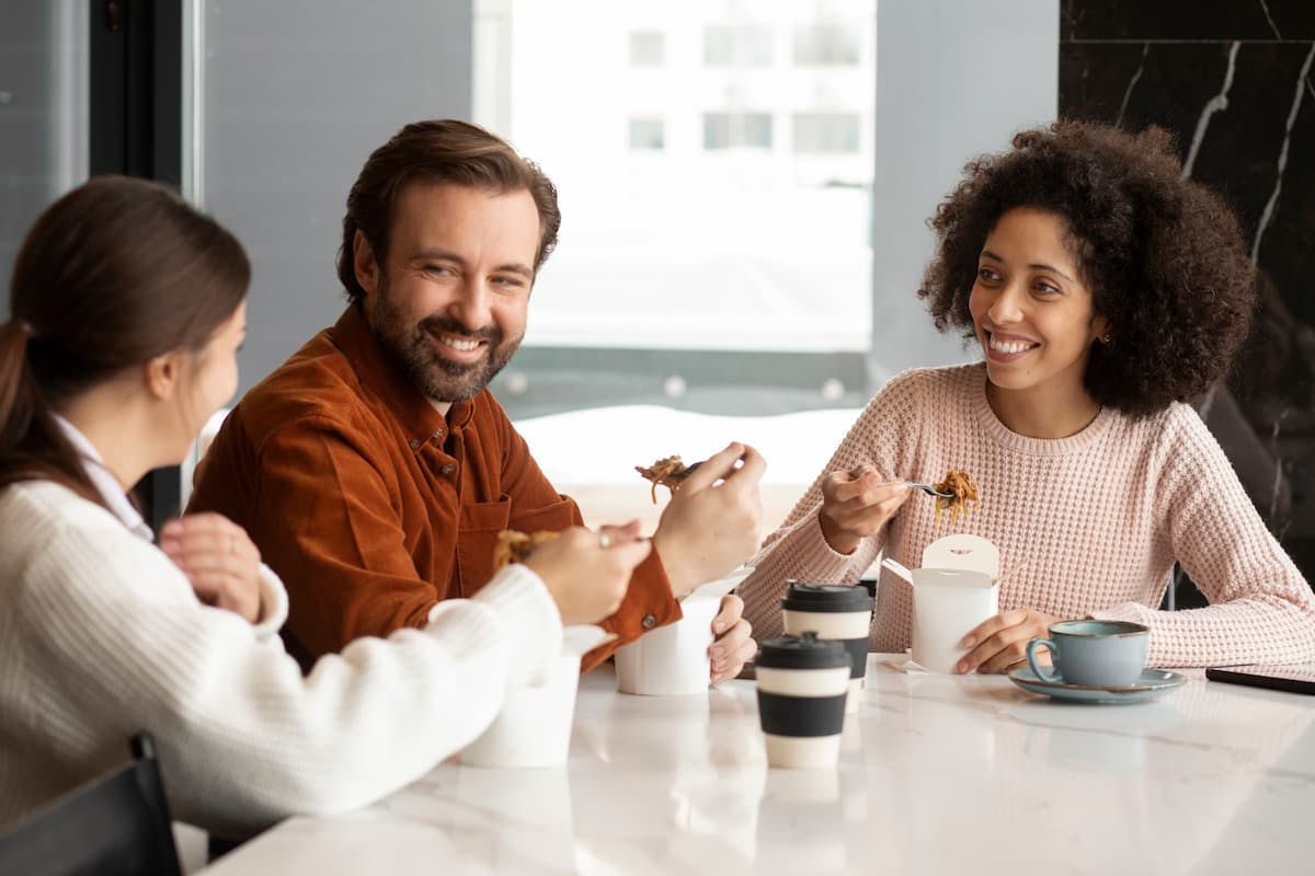 Coworkers enjoying a casual meal together, highlighting employee lunch programs vs. traditional food allowances at work.