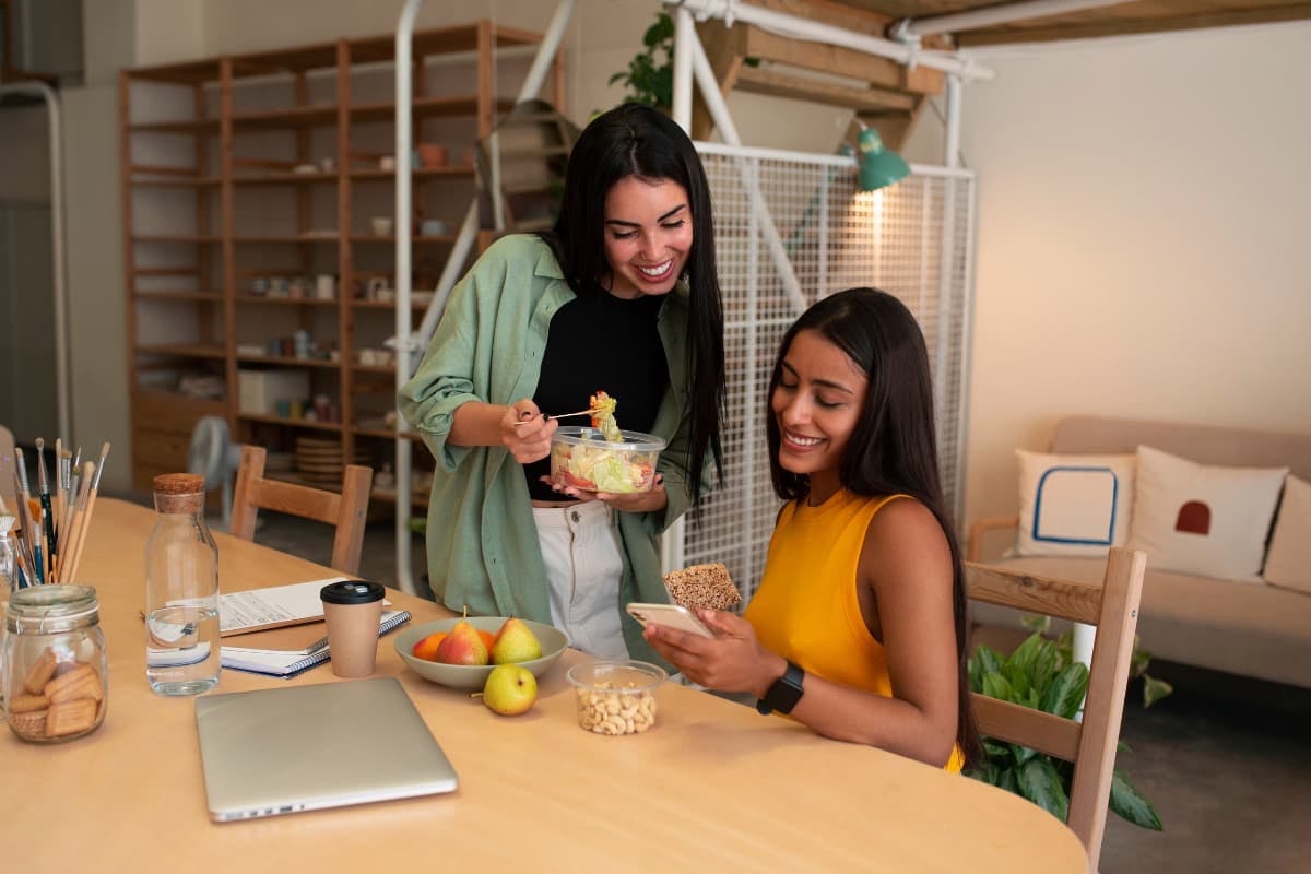 Two employees enjoying healthy meals, illustrating how to provide vegan and vegetarian lunch options in the office.