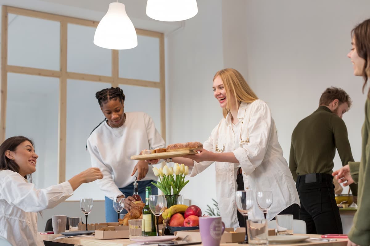 Team sharing food at the office, illustrating how to choose the right corporate catering service for company lunches.