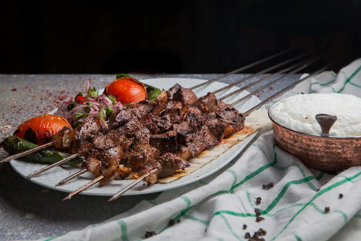 Grilled meat skewers with rice and vegetables, a savory option for food delivery in Irvine.