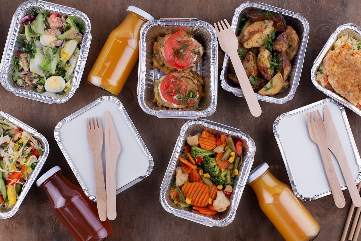 Assorted ready meals in containers and juices showing centralized meal ordering benefits like variety, efficiency, and consistency.