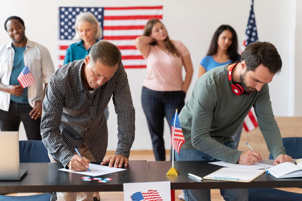 Employees signing papers at a patriotic-themed table, showing how to celebrate Independence Day at work with team activities.
