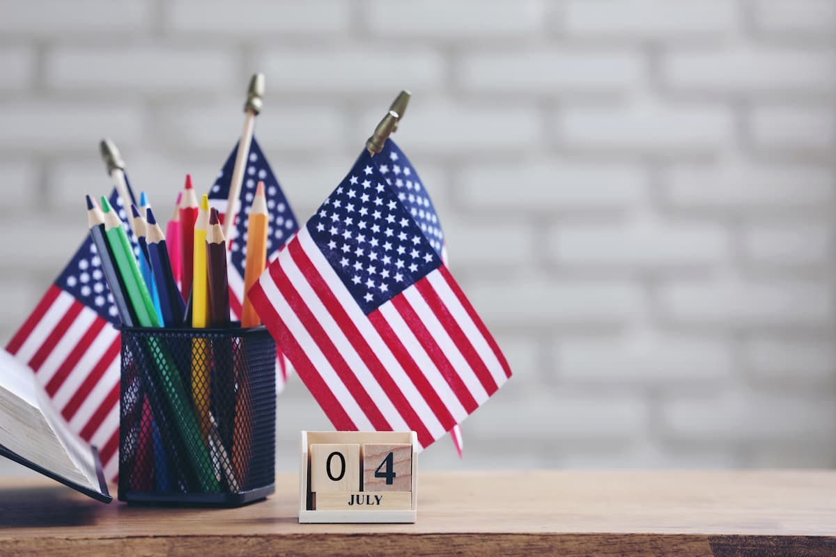 Desk decorated with U.S. flags and pencils, showing how to celebrate Independence Day at work with festive office decor.