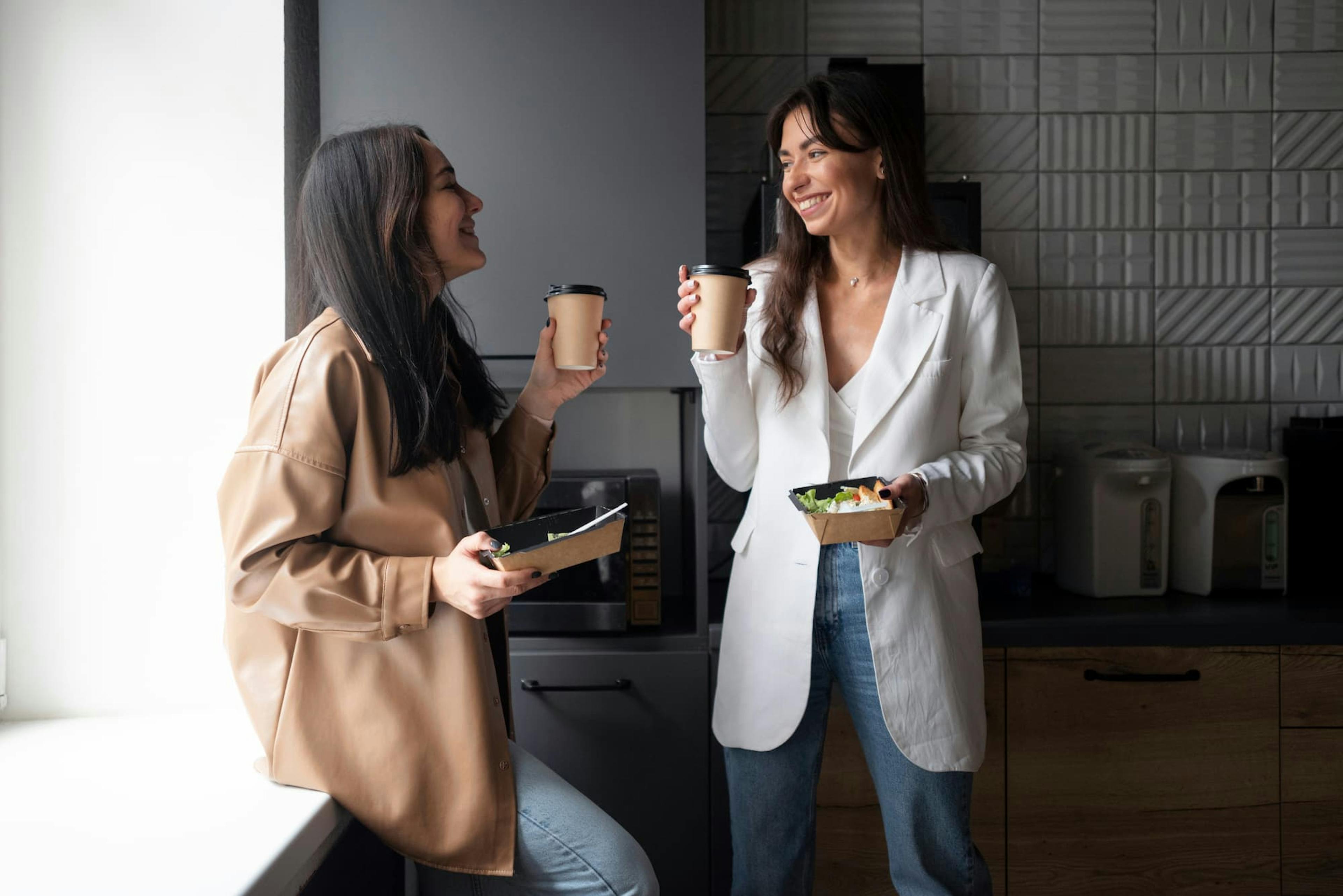 Enjoying coffee and salads, coworkers take a break with the most popular office lunch orders in hand.