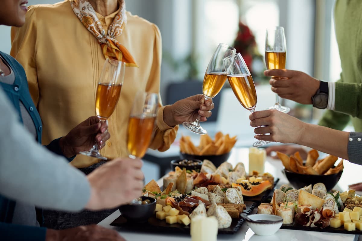 Colleagues toasting with drinks over appetizers—why consider catering corporate holiday party for a festive, stress-free event.