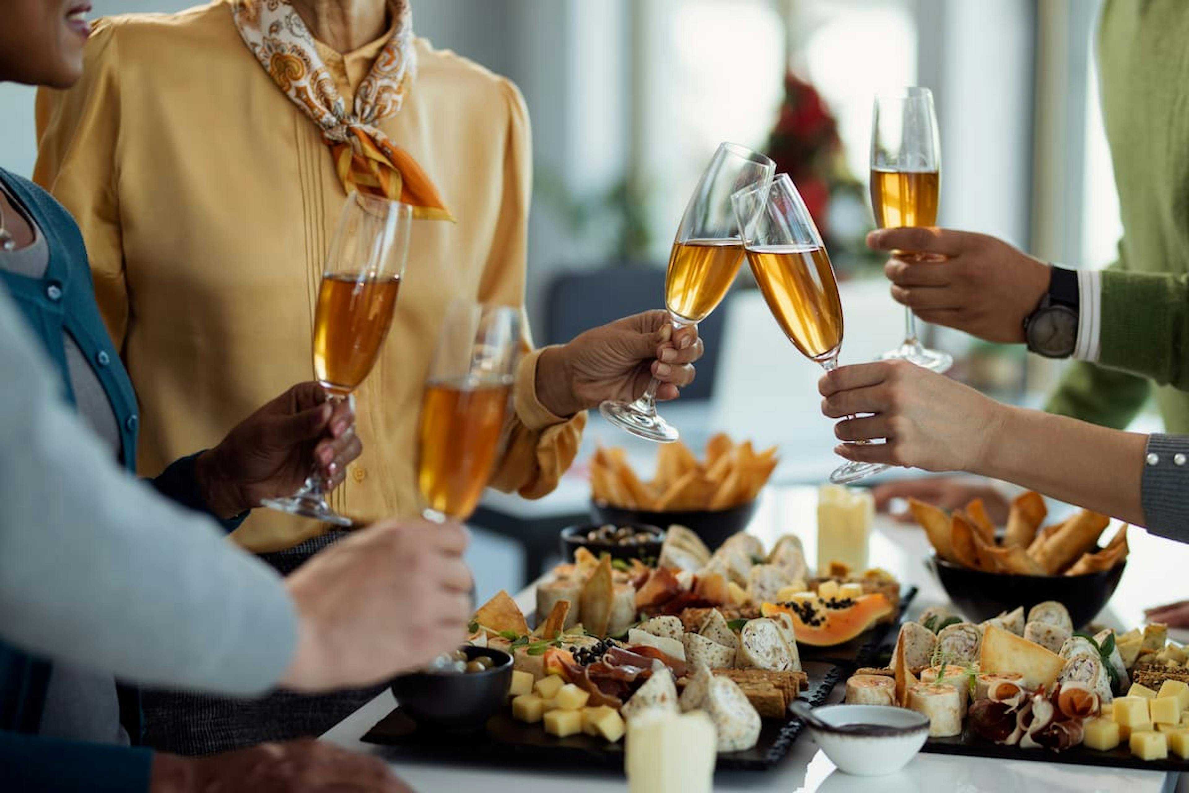 Colleagues toasting with drinks over appetizers—why consider catering corporate holiday party for a festive, stress-free event.