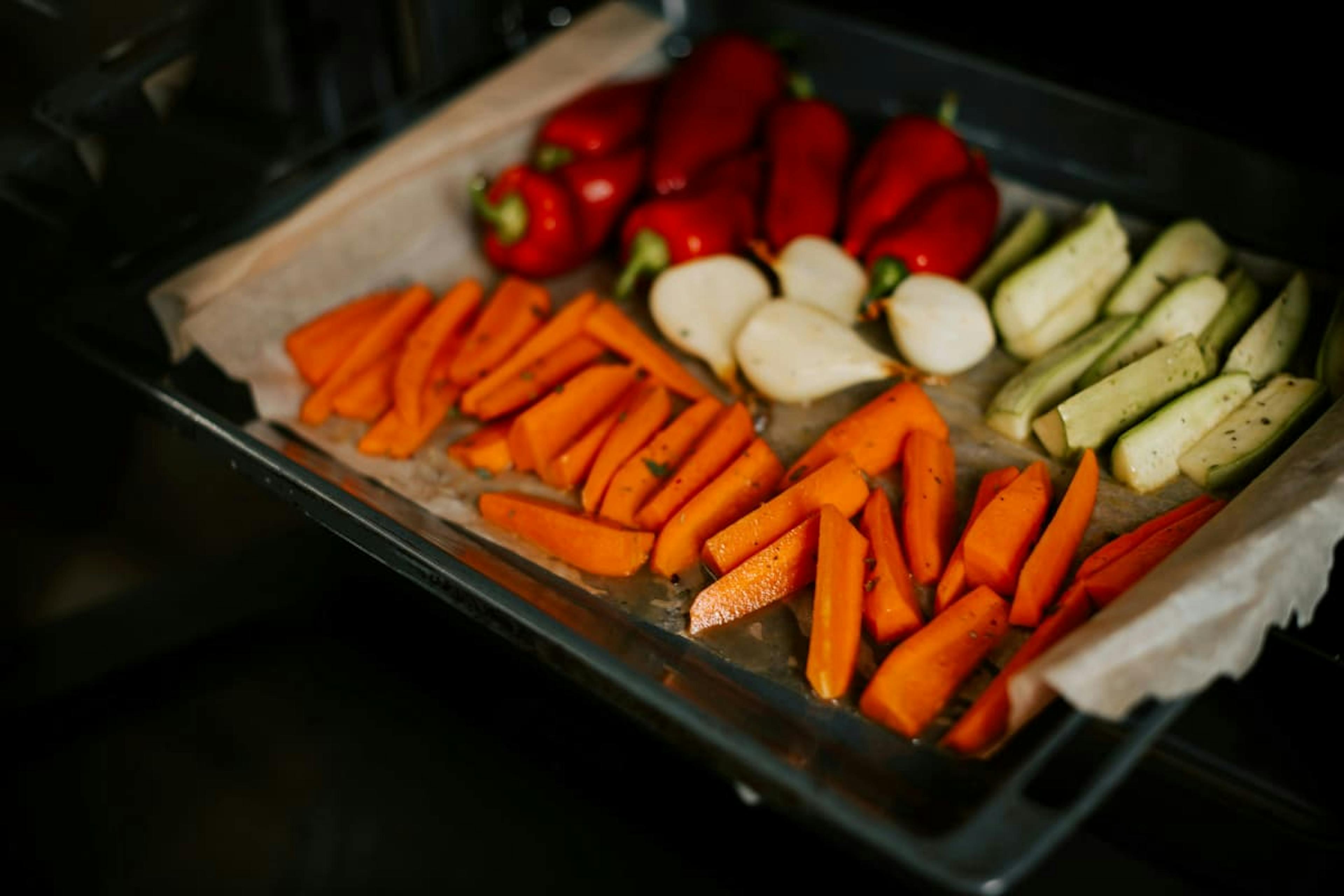 Tray of fresh roasted vegetables including carrots, zucchini, and peppers, perfect for healthy lunch delivery in Oakland.