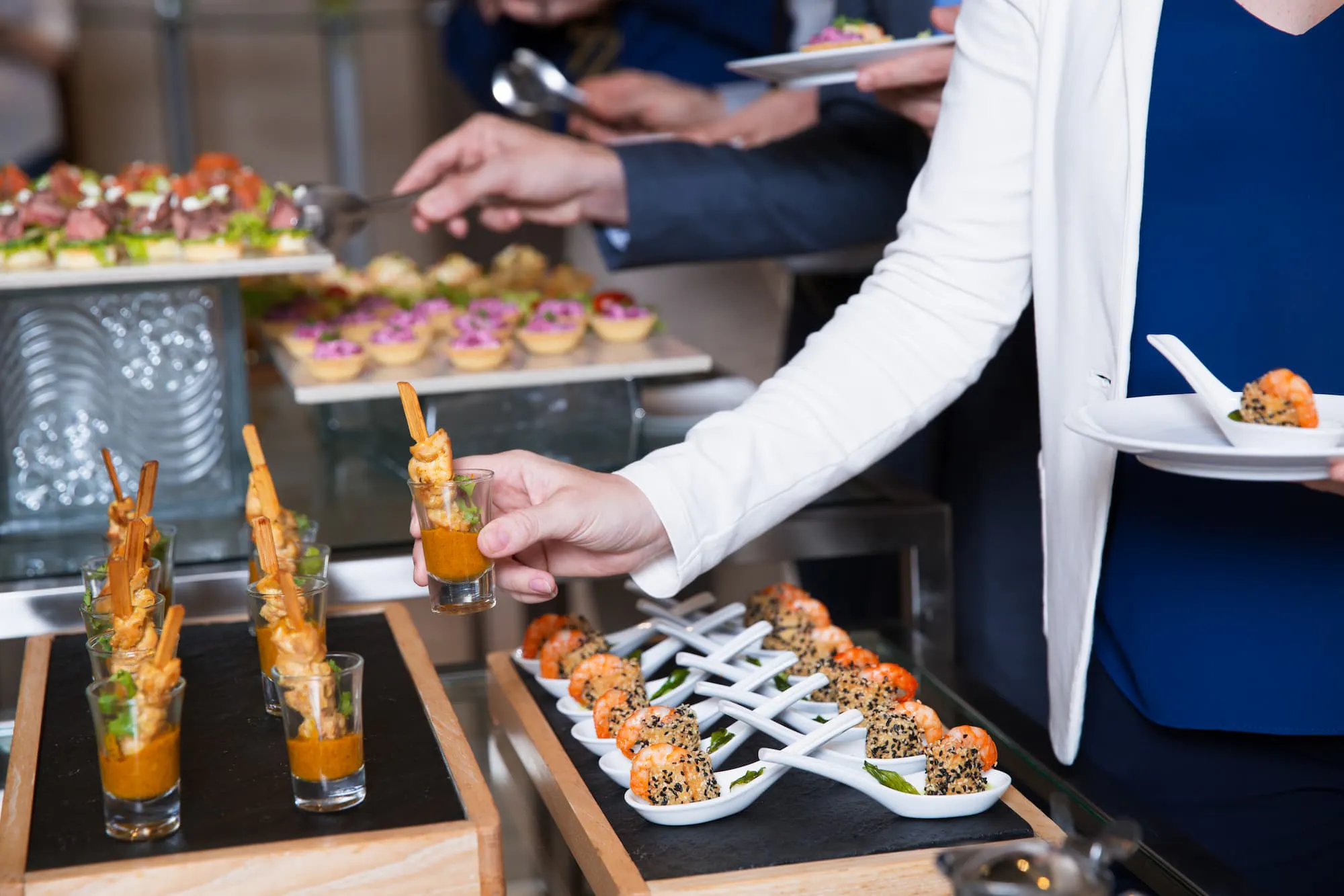 Guests serving gourmet appetizers, highlighting the benefits of buffet-style catering for corporate events with variety and ease.