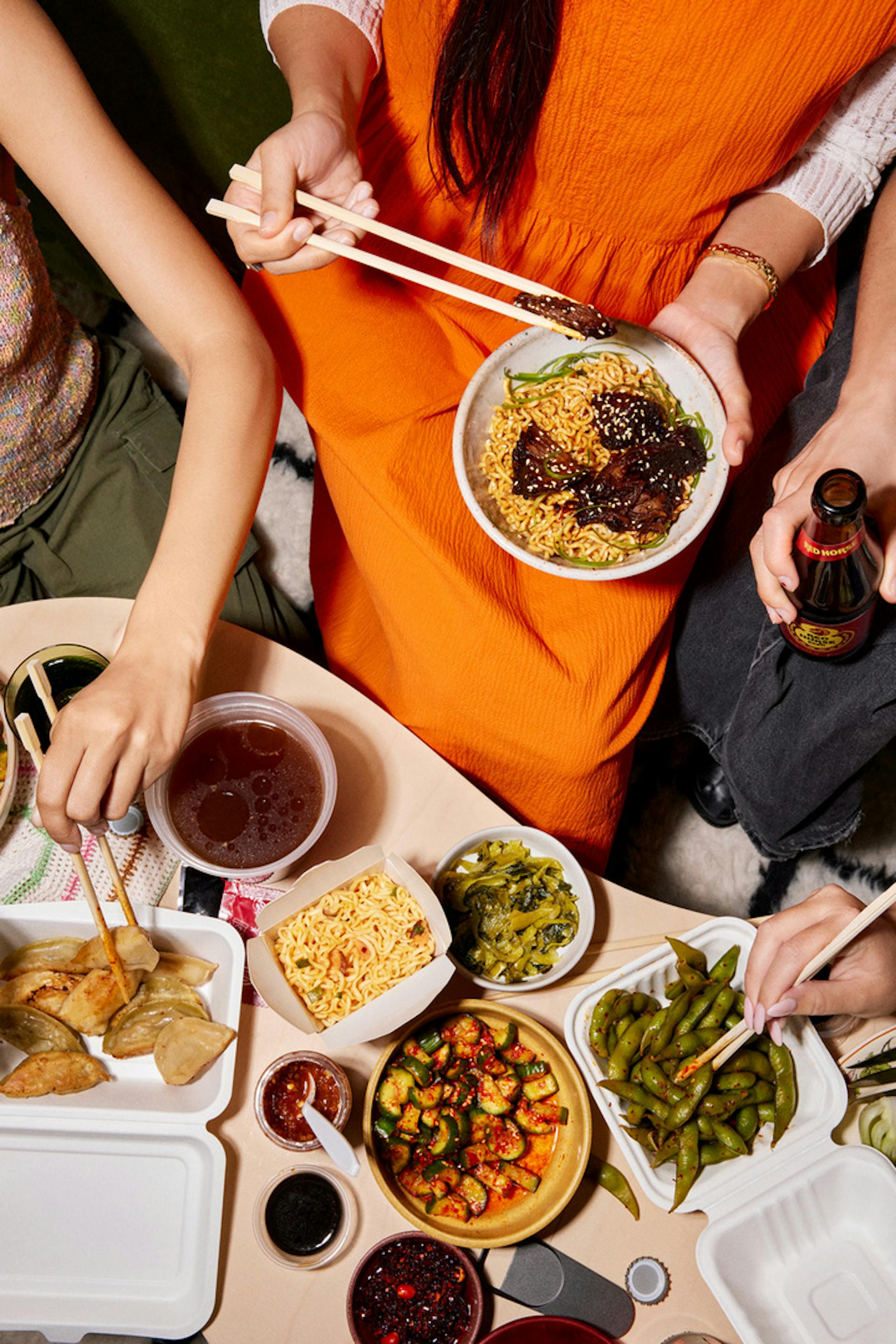 A group of people enjoying takeout with chopsticks.