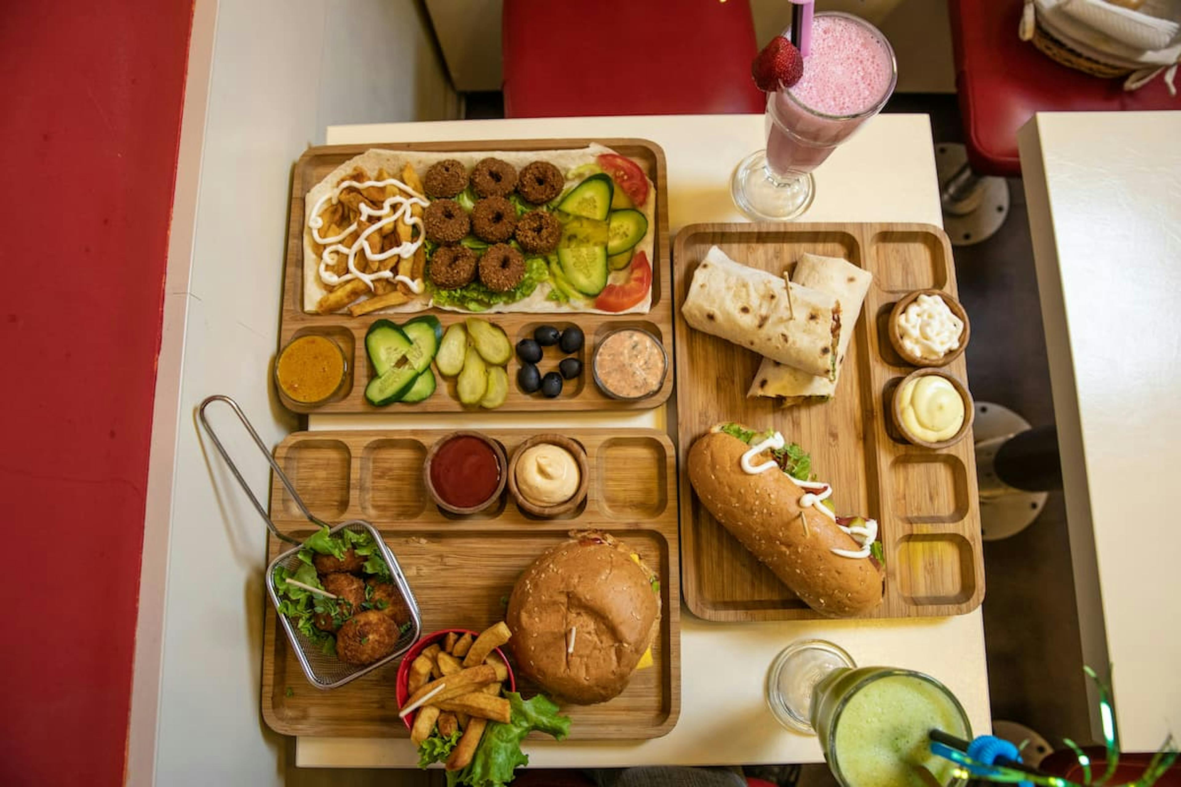Assorted affordable meals on trays in a casual setting, showing how to save money on office lunches by choosing budget-friendly options.