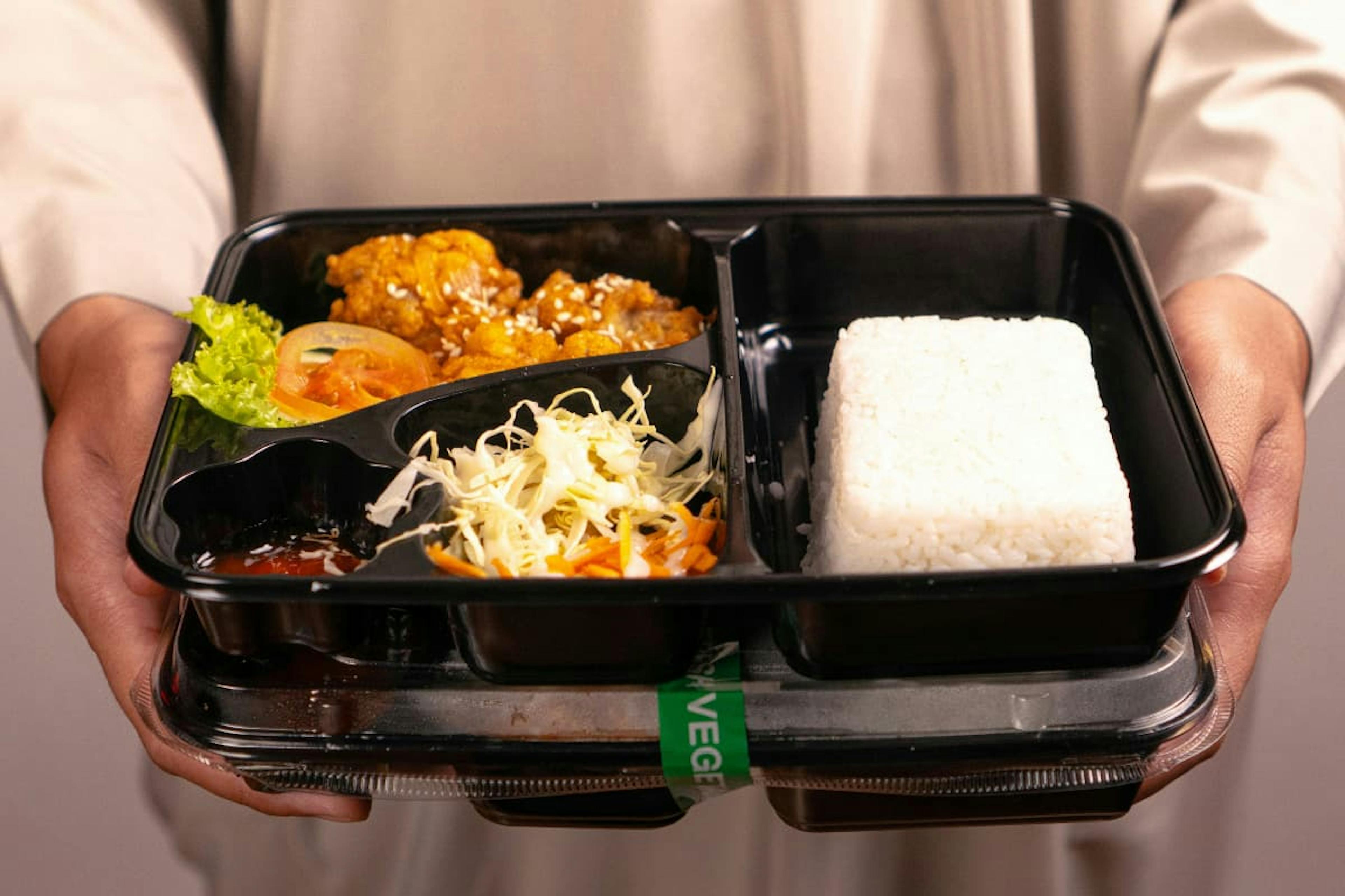 Homemade lunchbox with rice and vegetables showing how to save money on office lunches by bringing meals from home.