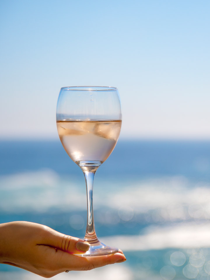 Glass of Rose with a glistening ocean behind