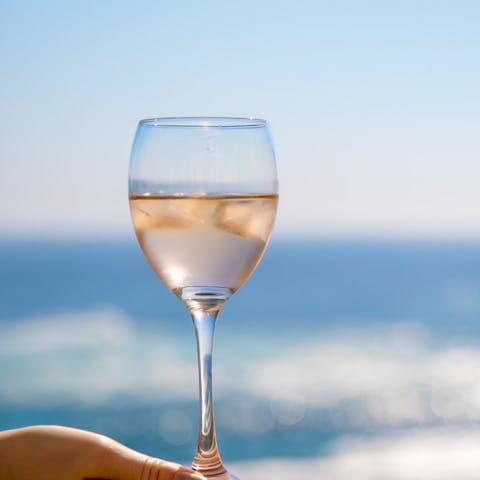 Glass of Rose with a glistening ocean behind