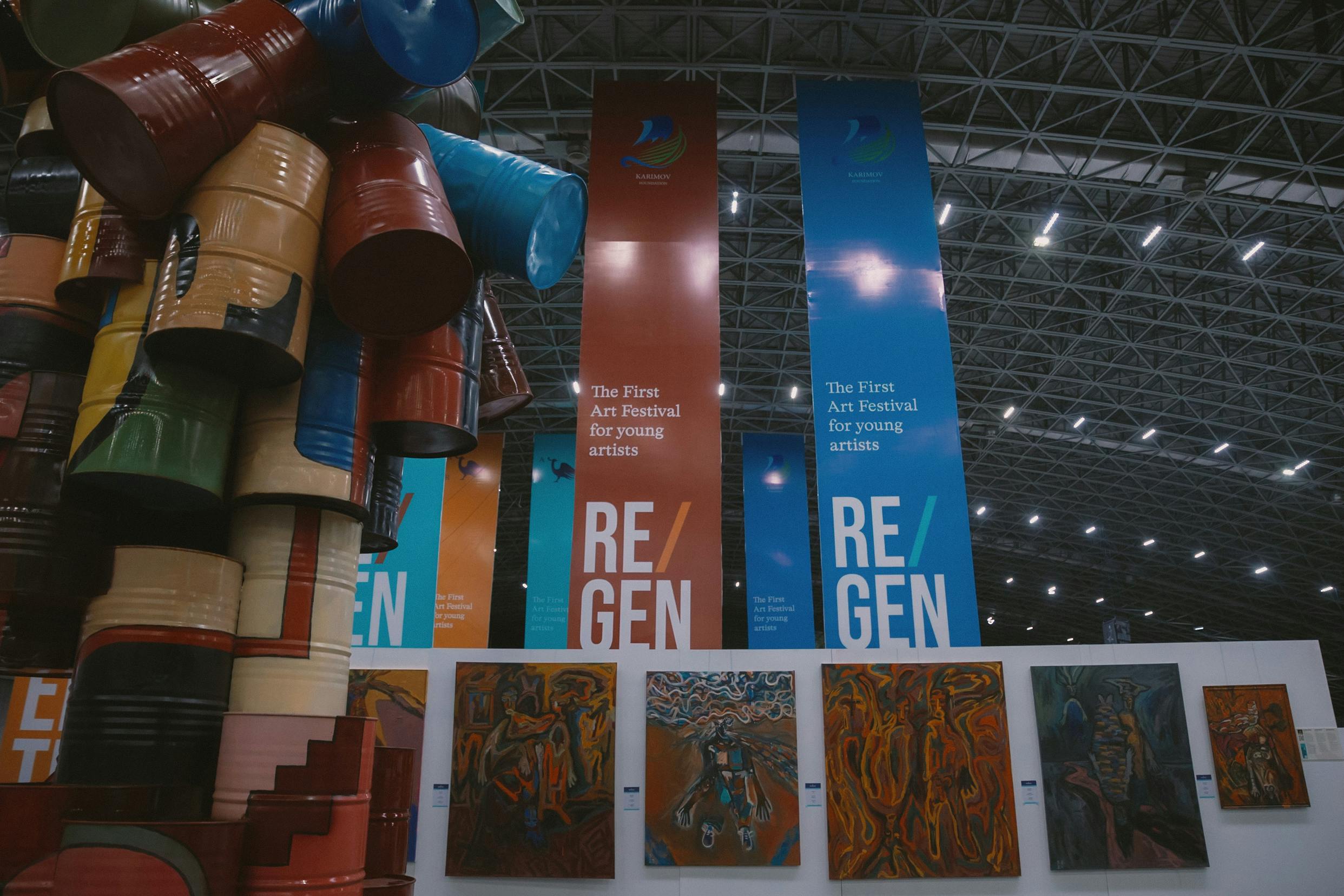 ReGeneration banners with wall of paintings and oil drum sculpture