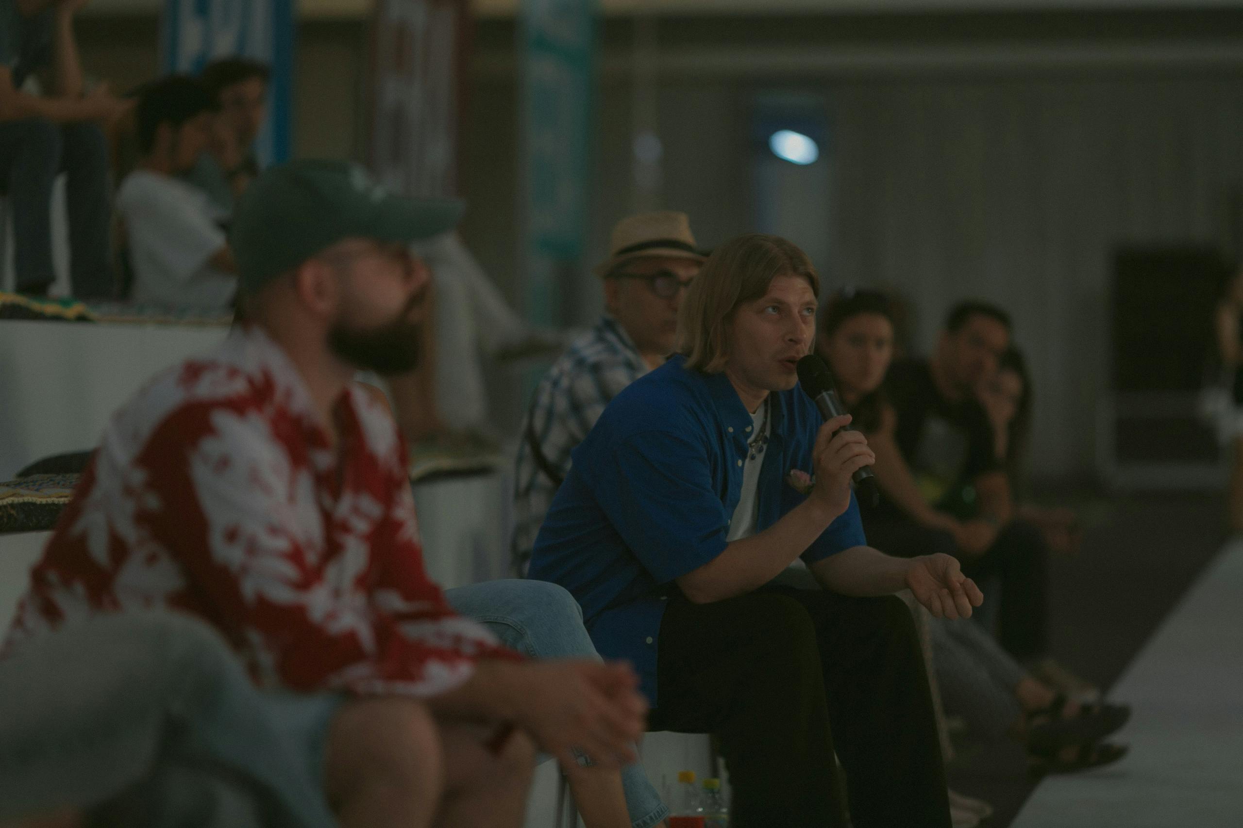 People sitting discussing art show dim lighting