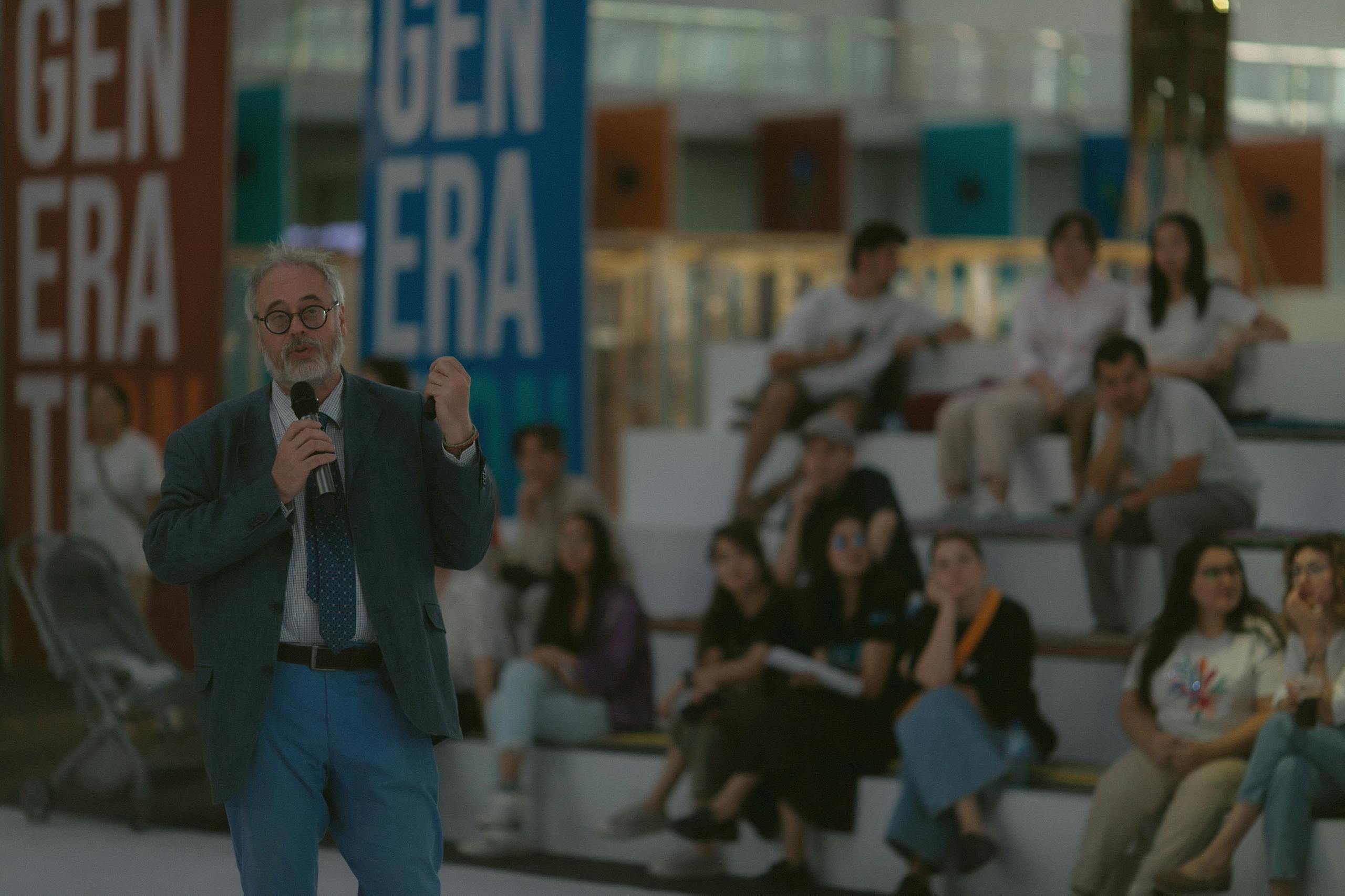 Man with beard speaking to crowd at Regeneration event