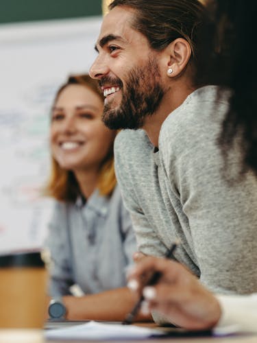 Two people smiling in a conference room