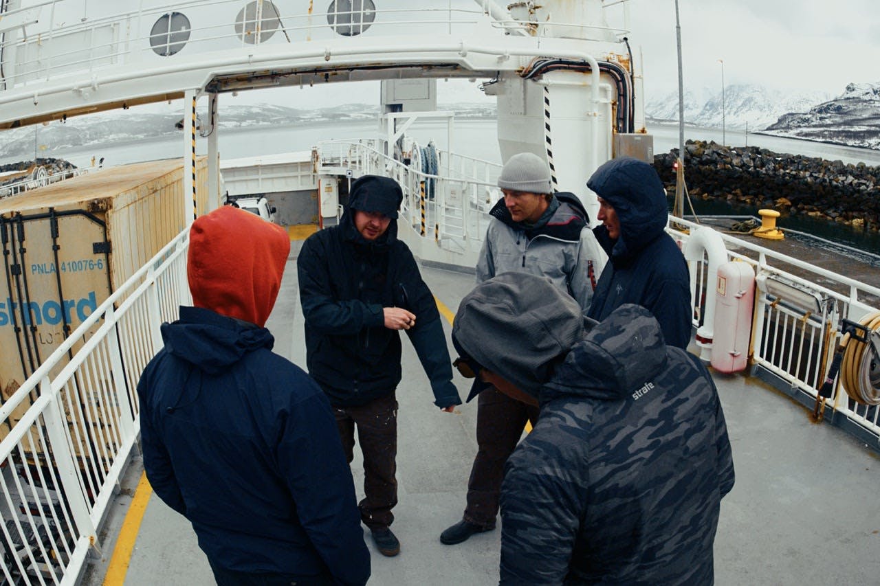 A group chatting on a cold ferry