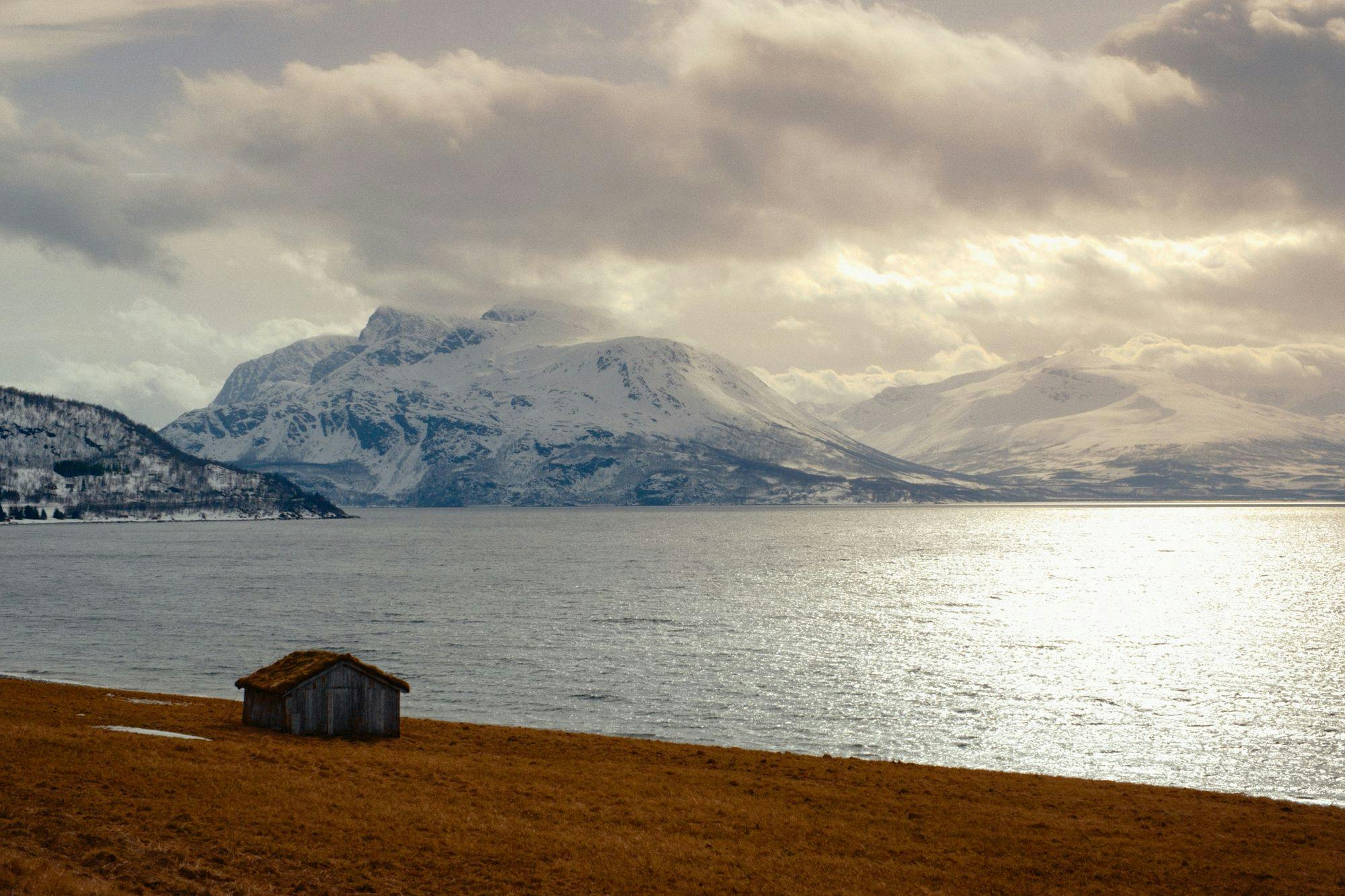 A farmhouse next to a wide open fjord