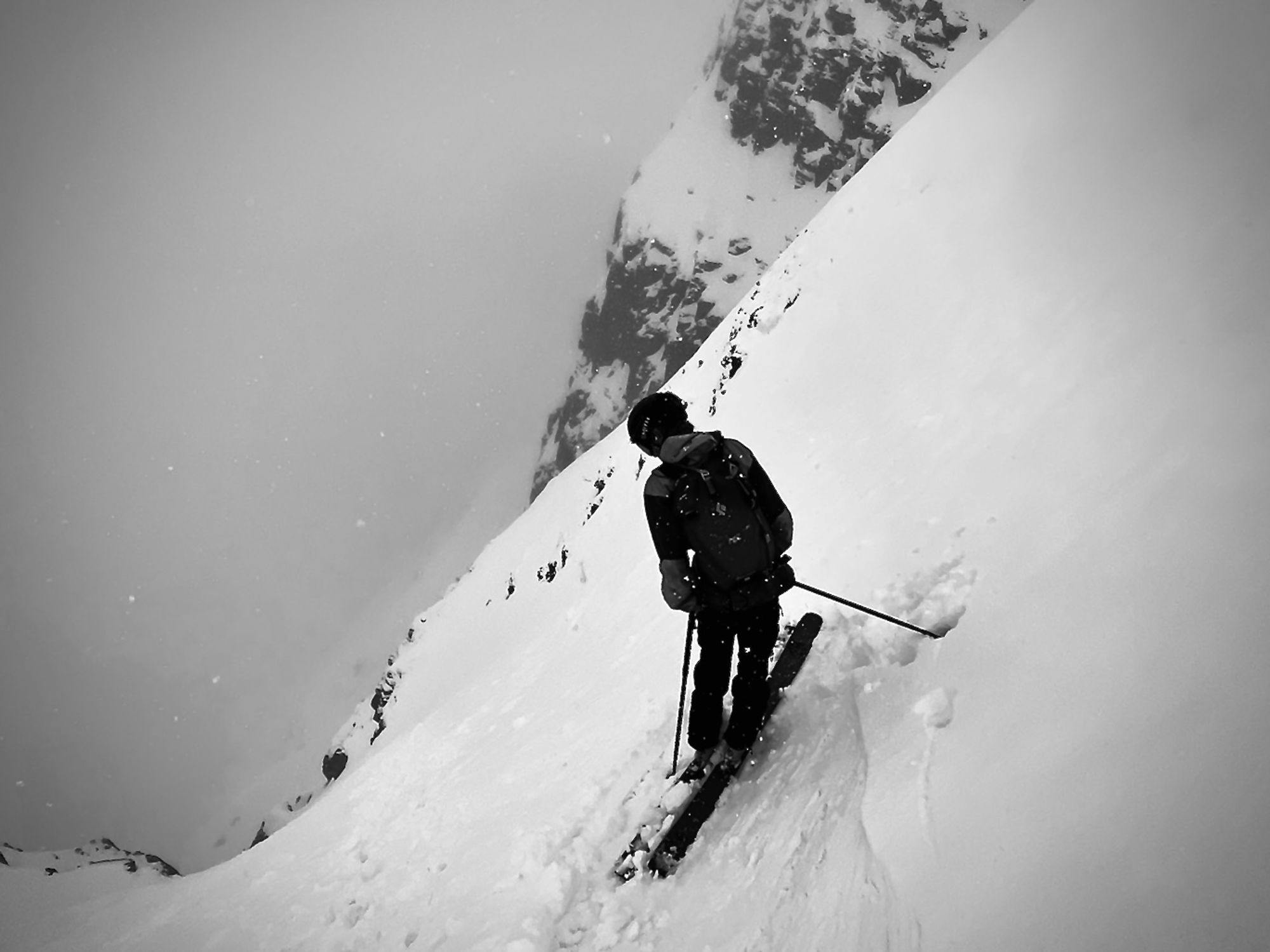 A skier looking into the clouds below him