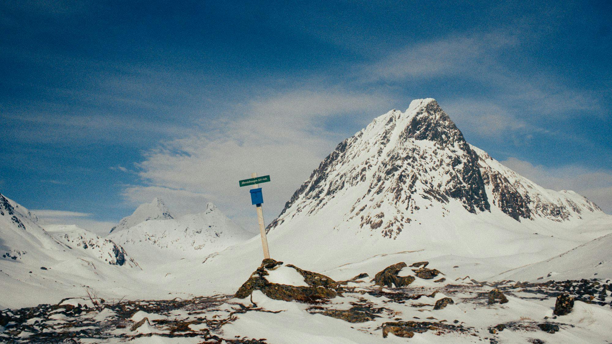 A sign with a mountain in back