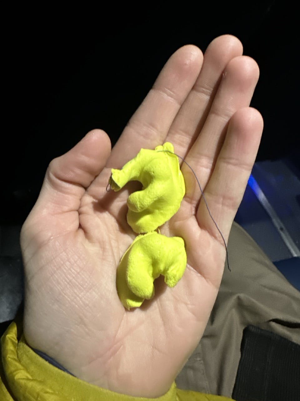 A photo of two ear plug molds in a palm of a hand