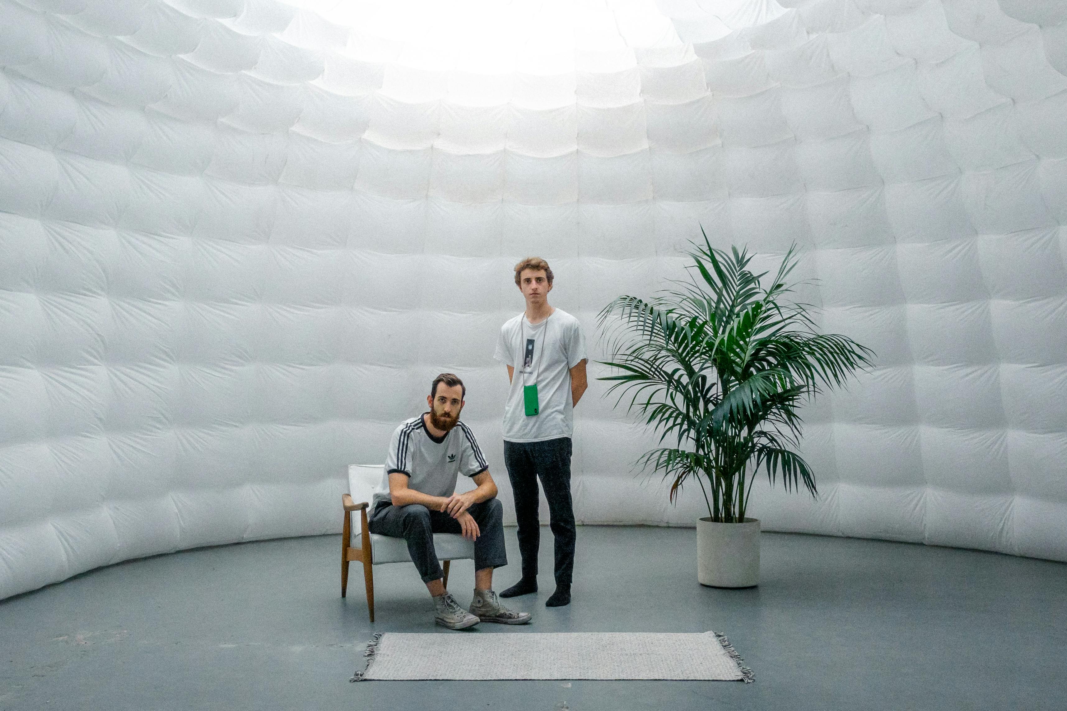 Two people inside of a white inflatable dome