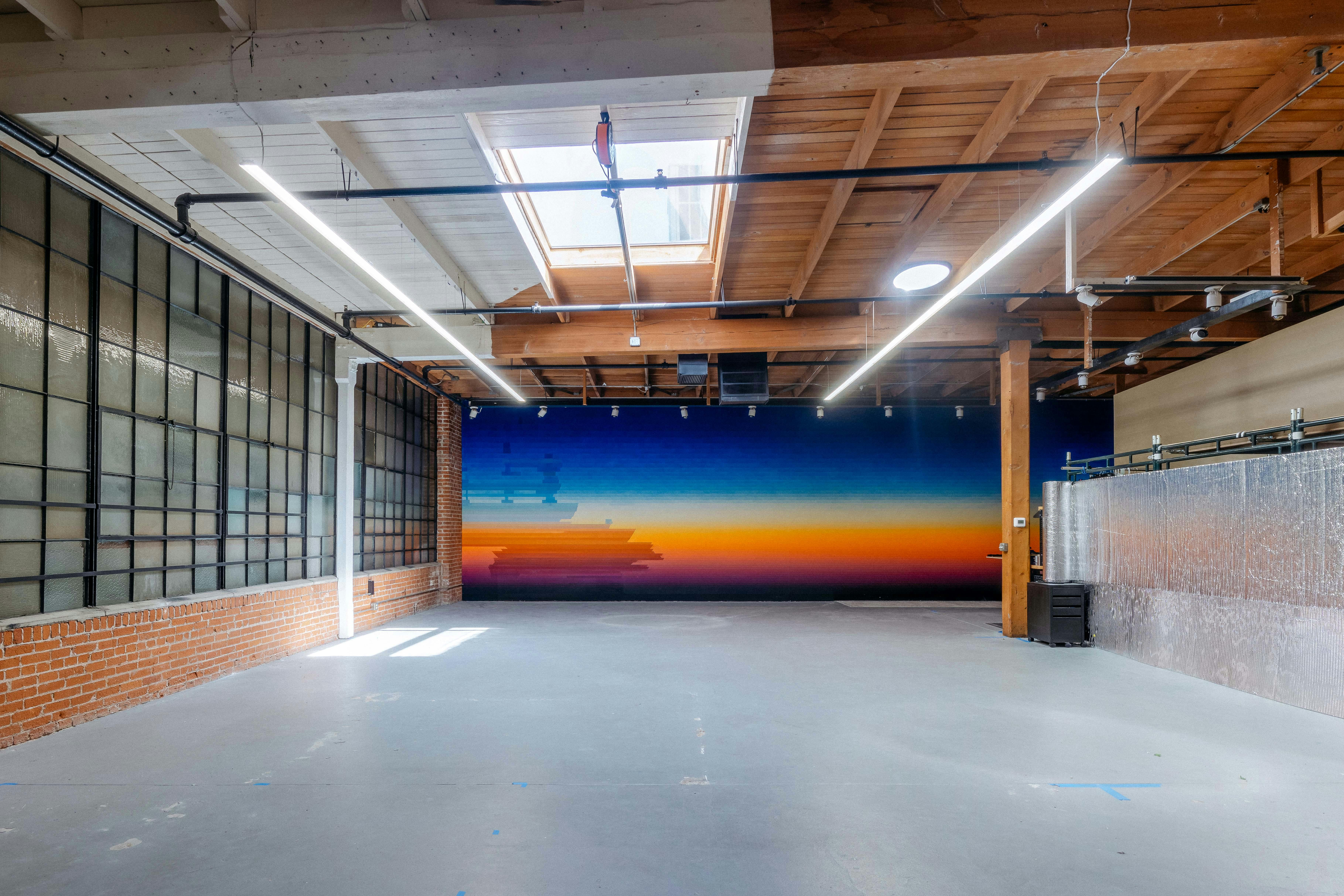 An empty studio space with a vibrant mural