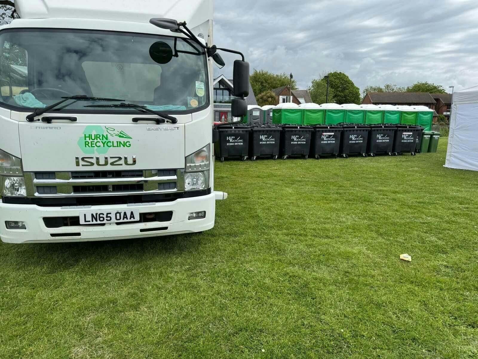 Lorry next to bins on grass