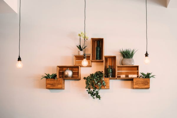Muur met houten kastjes, planten en lampen 
