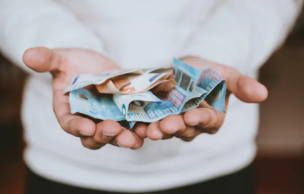 Briefjes geld in handen.