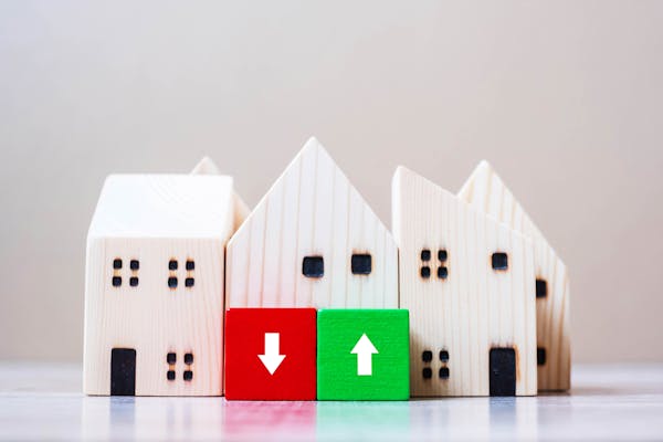 Houten huisjes met een rood blok van daling en een groen blok van stijging