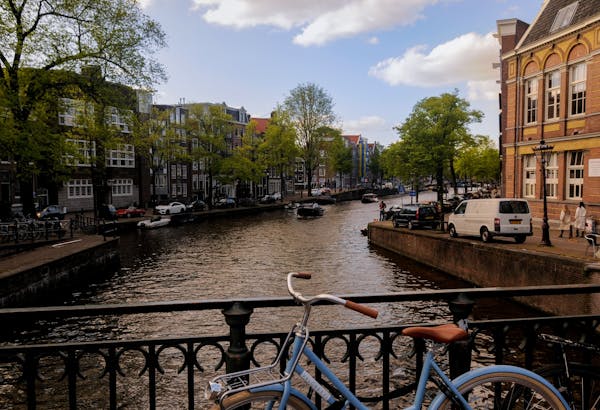 Gracht met huizen, fiets en auto's 