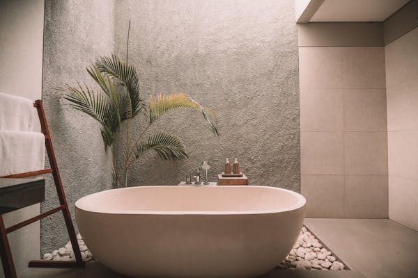 Luxe badkamer van tegels en steen met een plant