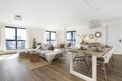 Lichte woonkamer met bank en eettafel 