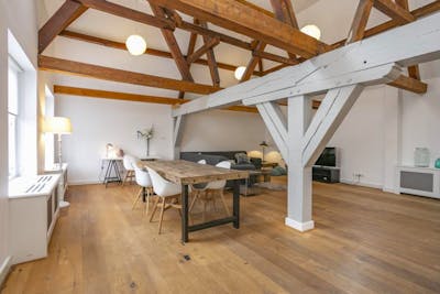 Woonkamer van hout met bank en eettafel 