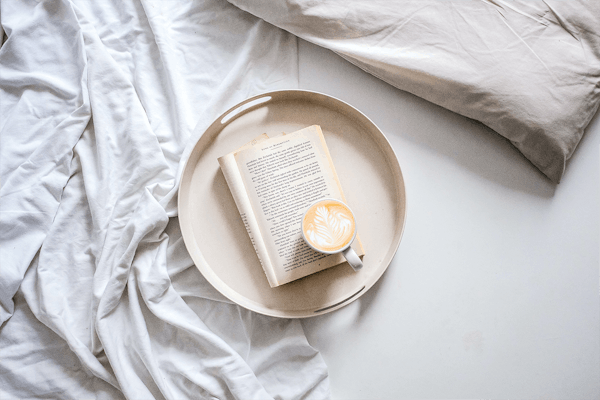 Koffie met boek op bed
