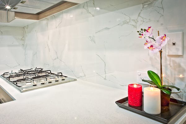 Witte keuken met marmeren tegels en kaarsen 