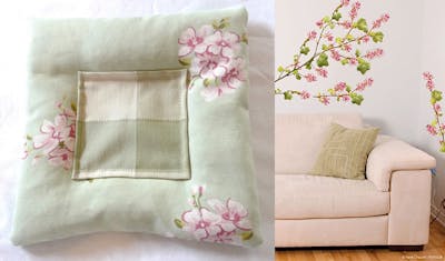 Groen kussen met bloemen en roze bank