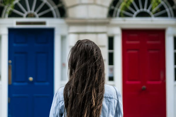Vrouw voor rode en blauwe deur