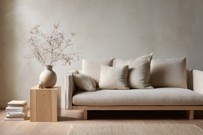 Bank met houten bijzet tafel met daarbovenop een stenen vaas