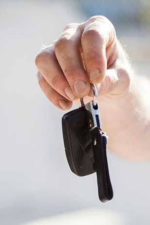 mies pitelee kädessään käytetyn auton avaimia