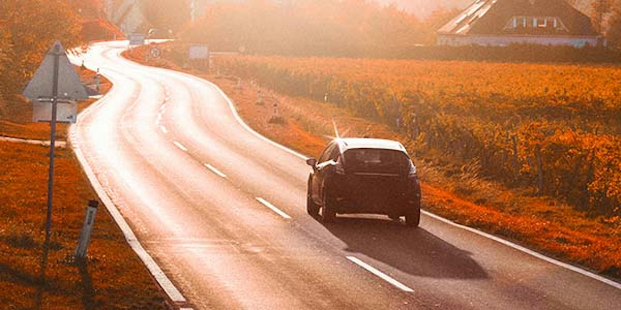 auto ajaa auringonlaskuun


