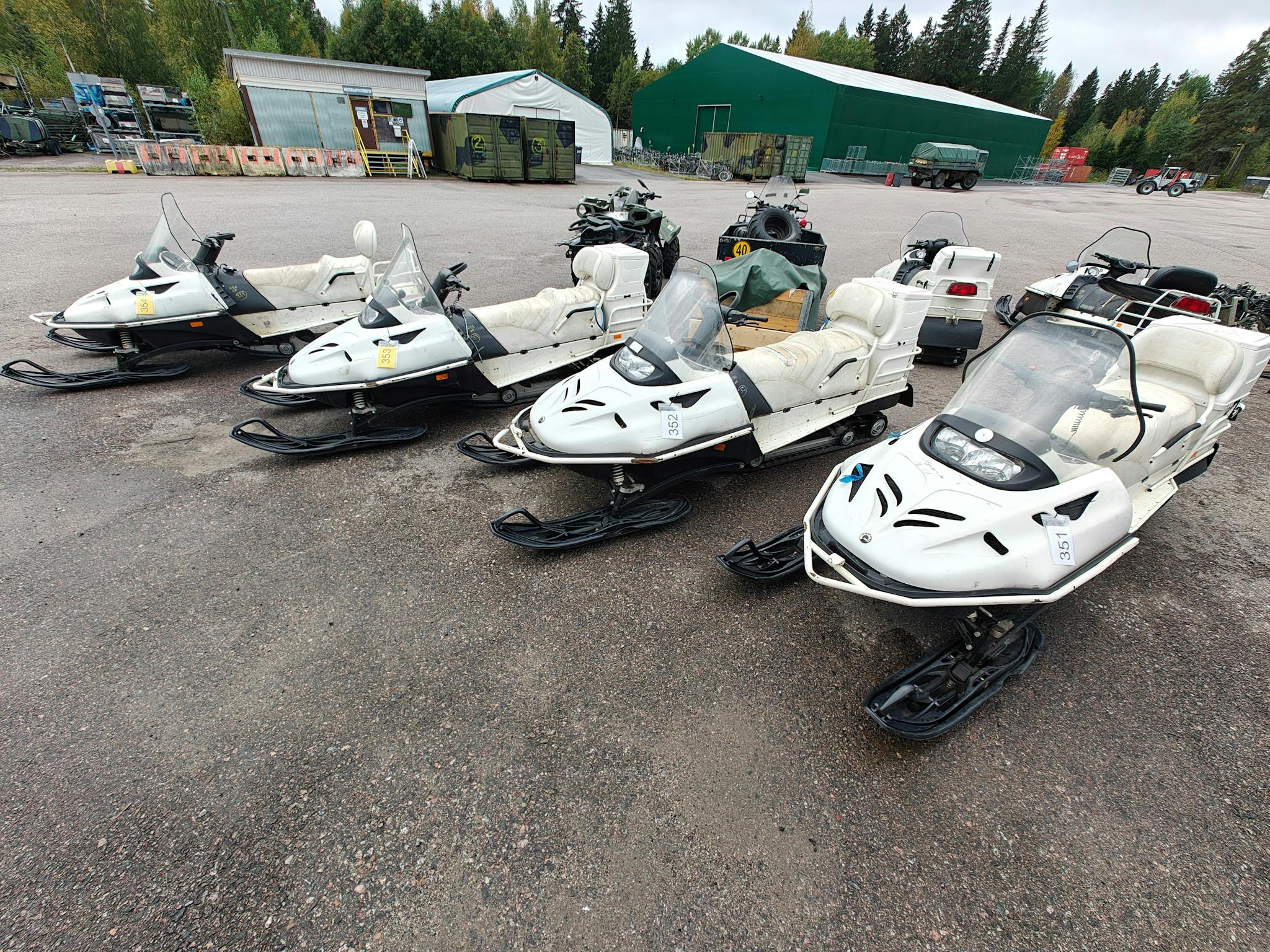 Neljä valkoista moottorikelkkaa rivissä