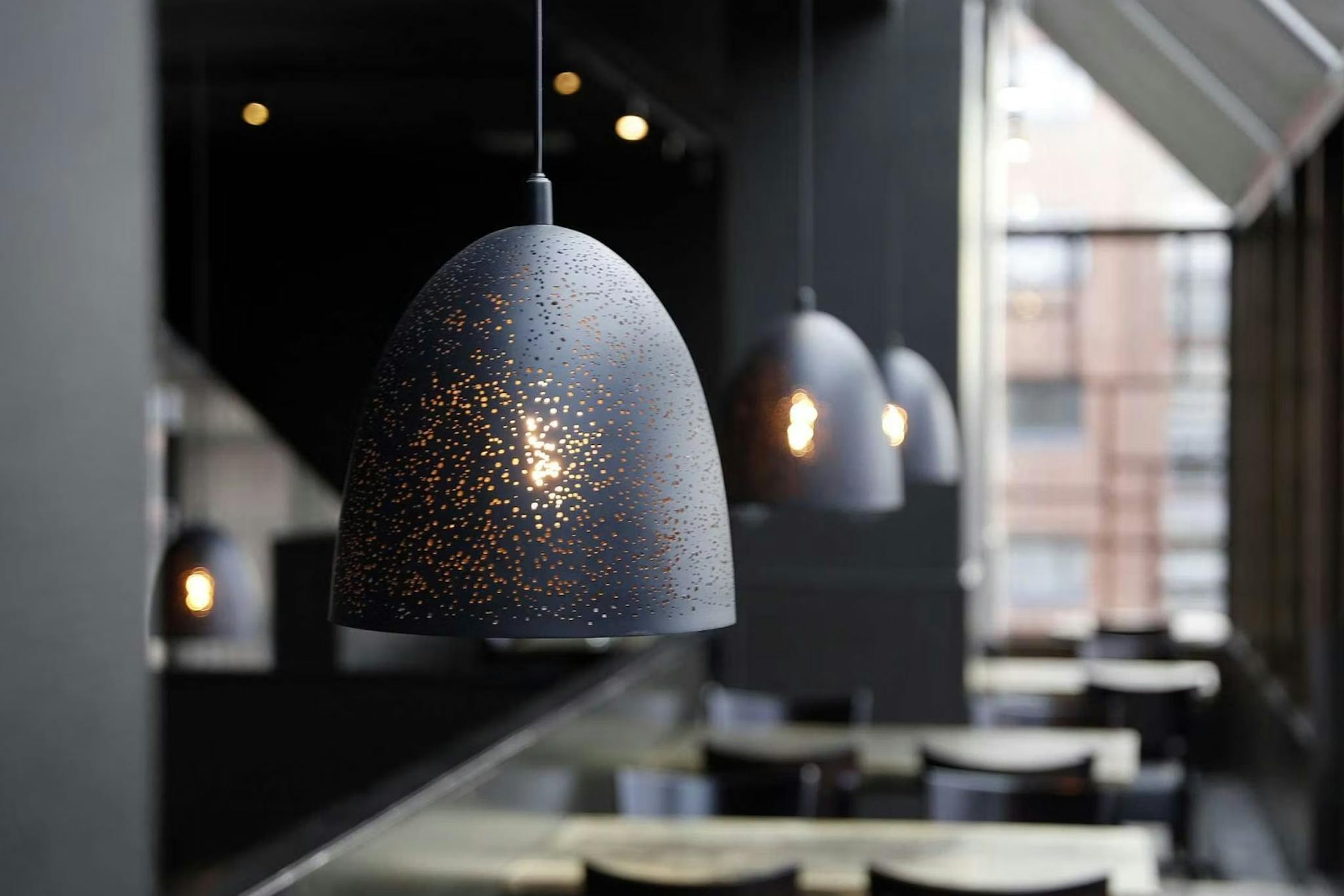 Mustat kattolamput pöytien päällä