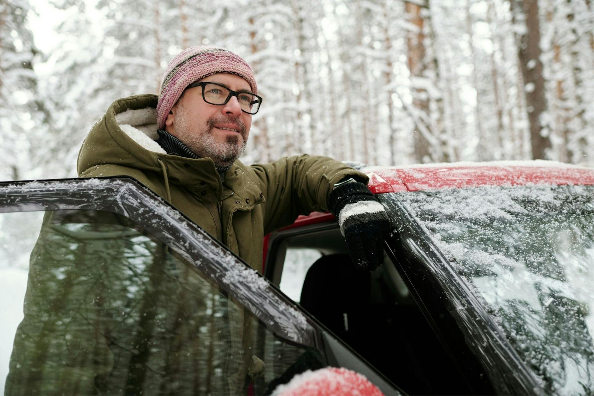 suomalainen mies talvisessa metsässä auton kanssa

