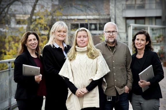 Fem personer som står utomhus